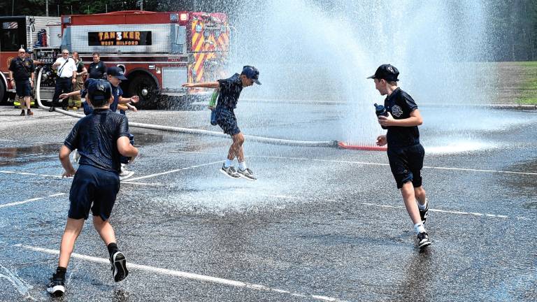West Milford Junior Police Academy cadets cool off in spray from a new specialized spraying device used by township firefighters. (Photos by Rich Adamonis)