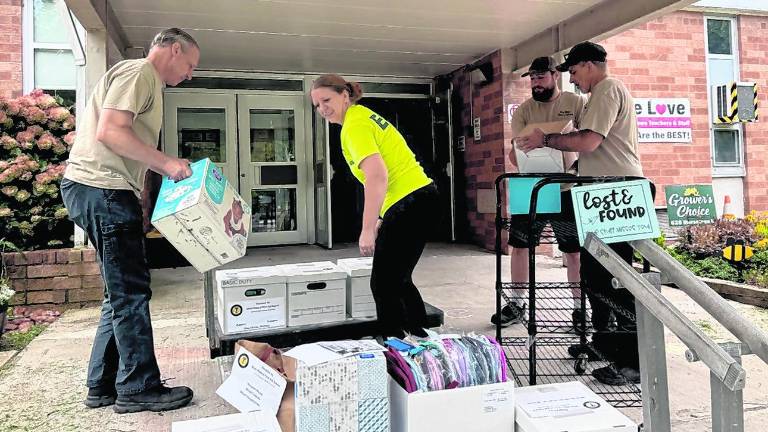 Members of the First Aid Squad pack up donated school supplies.