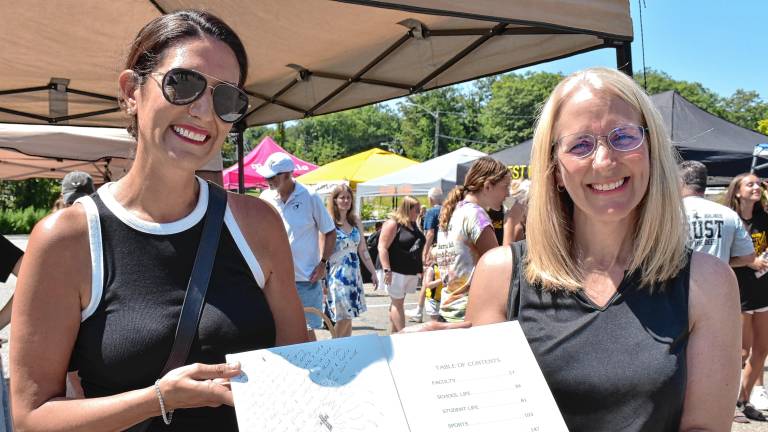 Jodie Chorbajian, left, and Heidi Gessler Cassels hold a West Milford High School yearbook from 1995 with a handwritten message from Jen Pawol. (Photos by Rich Adamonis)