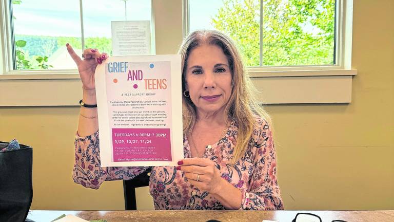 Maria Ojeda Pasterchick holds up a paper titled, Grief and Teens.