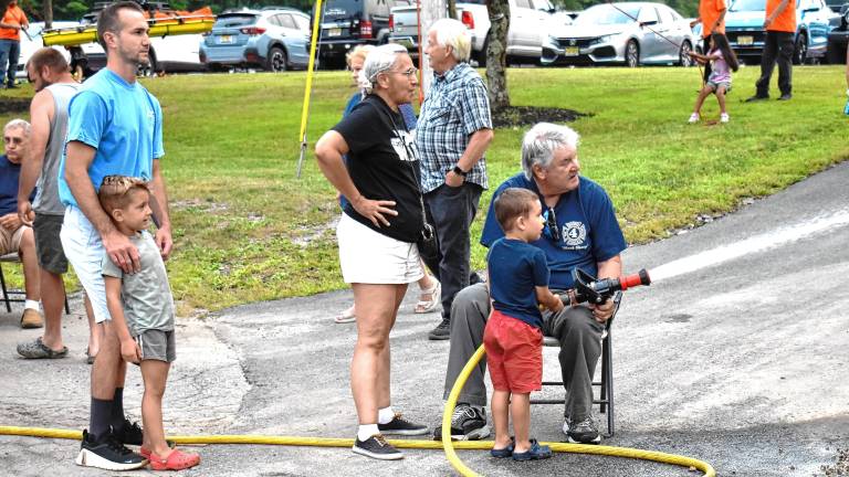A boy takes a turn pointing the fire hose during the National Night Out event Tuesday, Aug. 5 at West Milford High School. (Photos by Fred Ashplant)