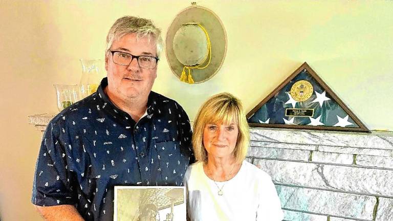Dave Smith and Kendall Kless at their home in Warwick, N.Y. He holds a photo of his father, Steve, a Vietnam War veteran who died in December. (Photo by Rich Adamonis)