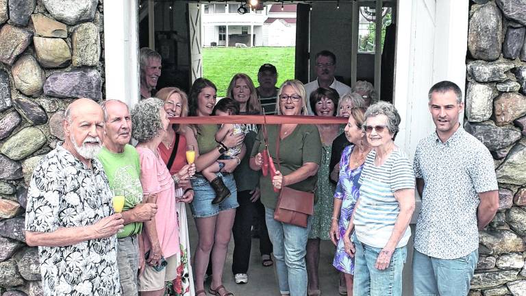 Wallisch Homestead board members and friends join Mayor Michele Dale, center, for the ribbon cutting for an expansive new 20’ x 40’ Trex deck that now stands at its historic barn.