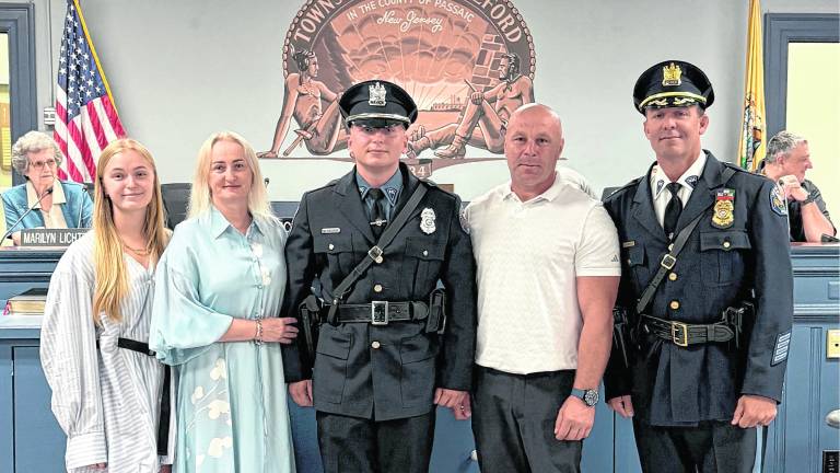 New West Milford police officer Mateusz Kaldon poses with family after being sworn in.