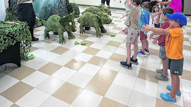 Ben Johnson and Mu Suriyalangka of Dinosaurs Alive lead the children in a dance.