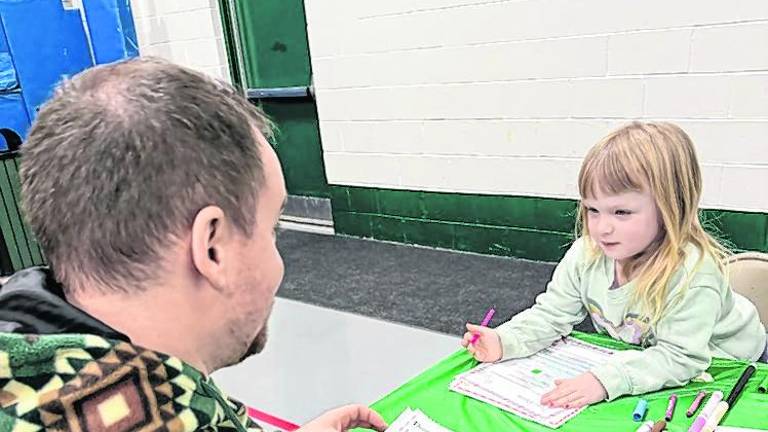 Juniper Savage Foley, 4, of West Milford writes her letter to Santa as her father, Jim Foley, looks on.