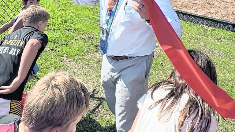 Marshall Hill Elementary School principal Patrick O’Donnell cuts the ribbon on the school’s new playground.