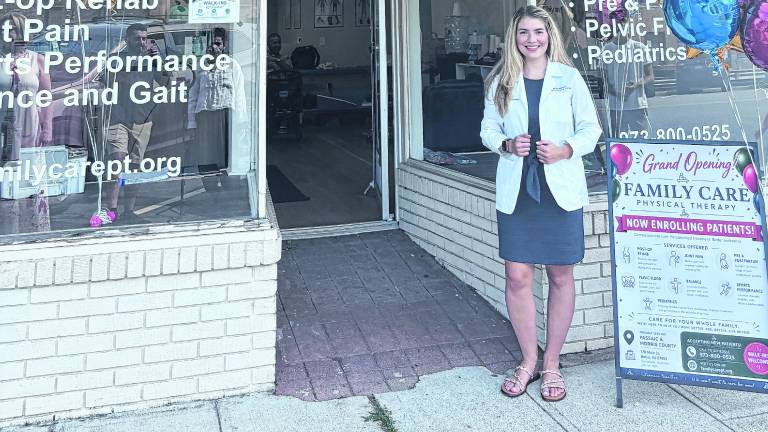 Dr. Nicole Mustafa poses in front of Family Care Physical Therapy.