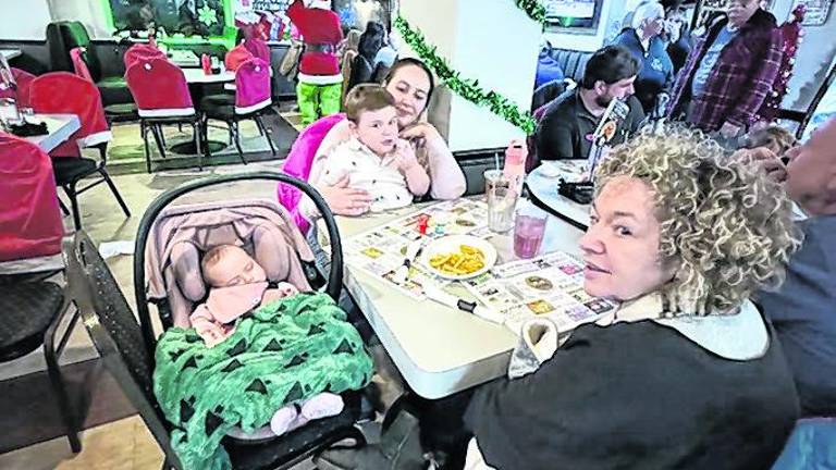 The Mazzola family with children ages 3 and 5 months are enjoying dinner with the Grinch.