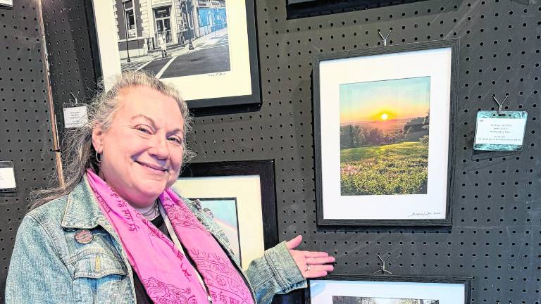 Sarah Loukos stands with her piece, Last Day's Glow.